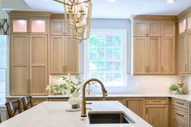 White oak kitchen with sage green island and white quartzite waterfall counters in Raleigh, NC