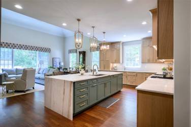 White oak kitchen with sage green island and white quartzite waterfall counters in Raleigh, NC