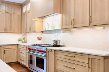 White oak kitchen with sage green island and white quartzite waterfall counters in Raleigh, NC