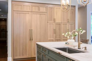 White oak kitchen with sage green island and white quartzite waterfall counters in Raleigh, NC