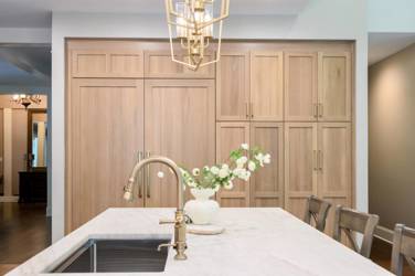 White oak kitchen with sage green island and white quartzite waterfall counters in Raleigh, NC