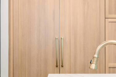 White oak kitchen with sage green island and white quartzite waterfall counters in Raleigh, NC