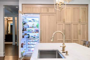 White oak kitchen with sage green island and white quartzite waterfall counters in Raleigh, NC