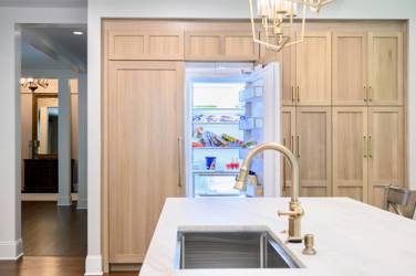 White oak kitchen with sage green island and white quartzite waterfall counters in Raleigh, NC