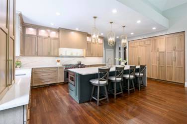White oak kitchen with sage green island and white quartzite waterfall counters in Raleigh, NC