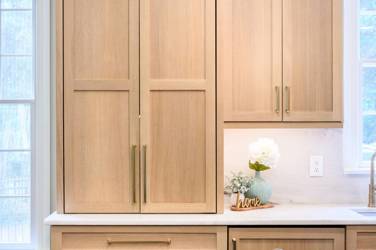White oak kitchen with sage green island and white quartzite waterfall counters in Raleigh, NC