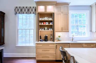 White oak kitchen with sage green island and white quartzite waterfall counters in Raleigh, NC