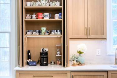 White oak kitchen with sage green island and white quartzite waterfall counters in Raleigh, NC