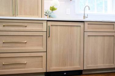 White oak kitchen with sage green island and white quartzite waterfall counters in Raleigh, NC