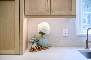 White oak kitchen with sage green island and white quartzite waterfall counters in Raleigh, NC