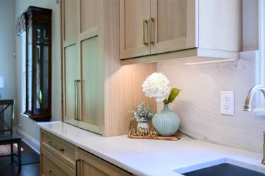 White oak kitchen with sage green island and white quartzite waterfall counters in Raleigh, NC