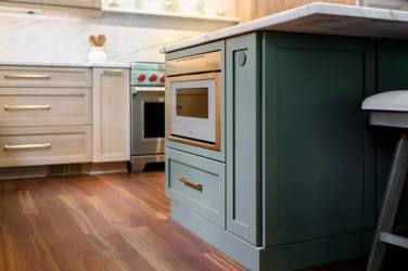 White oak kitchen with sage green island and white quartzite waterfall counters in Raleigh, NC