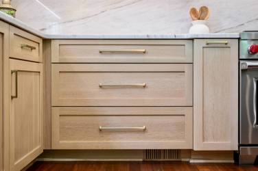 White oak kitchen with sage green island and white quartzite waterfall counters in Raleigh, NC