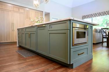 White oak kitchen with sage green island and white quartzite waterfall counters in Raleigh, NC