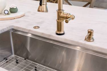 White oak kitchen with sage green island and white quartzite waterfall counters in Raleigh, NC