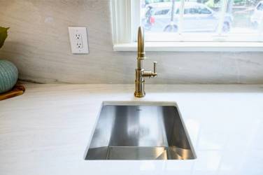 White oak kitchen with sage green island and white quartzite waterfall counters in Raleigh, NC