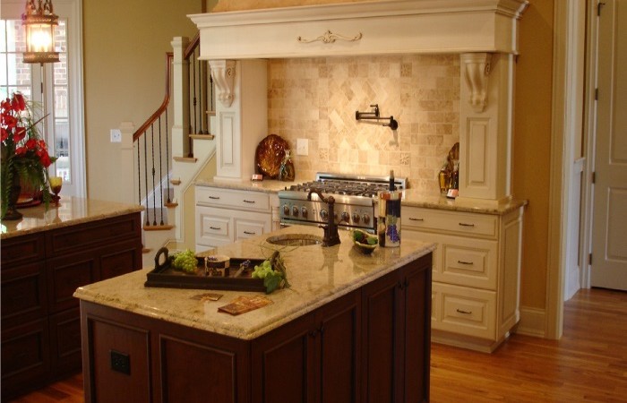 Custom kitchen design to allow cooking with prep sink and custom hood mantel for Wolf Range